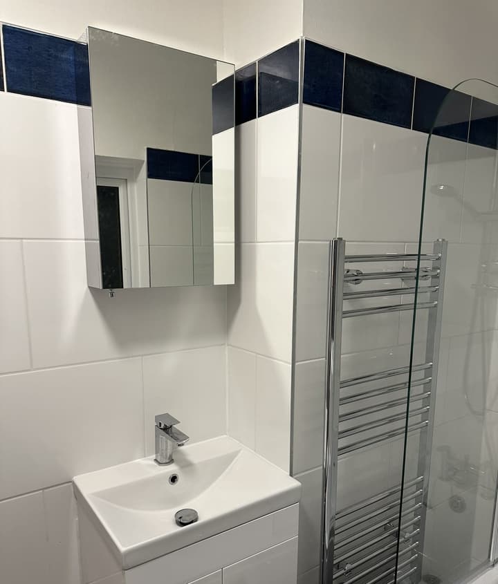 Vanity basin with mixer tap, mirrored cabinet and chrome heated towel rail in the renovated Barnet bathroom