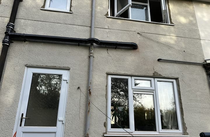 Rear wall of the Barnet house after renovation, showing the new black soil and waste pipework run