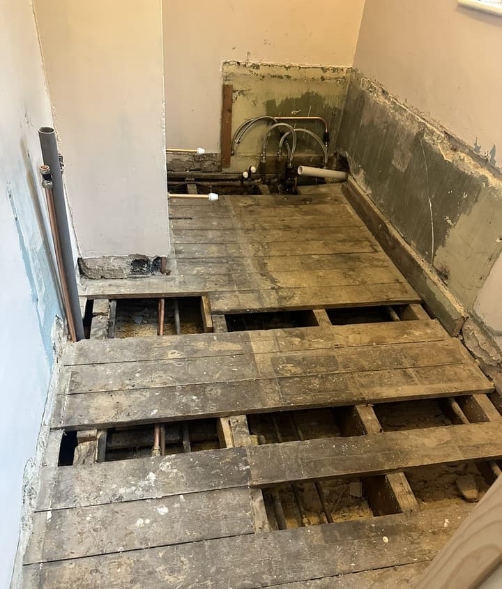 Barnet bathroom stripped back to the joists, with new copper supply pipes and flexible connectors ready for the new suite